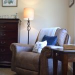 Lamp, Comfortable Chair, and Dresser with Side Table