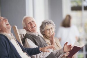 Elderly friends laughing while in rocking chairs